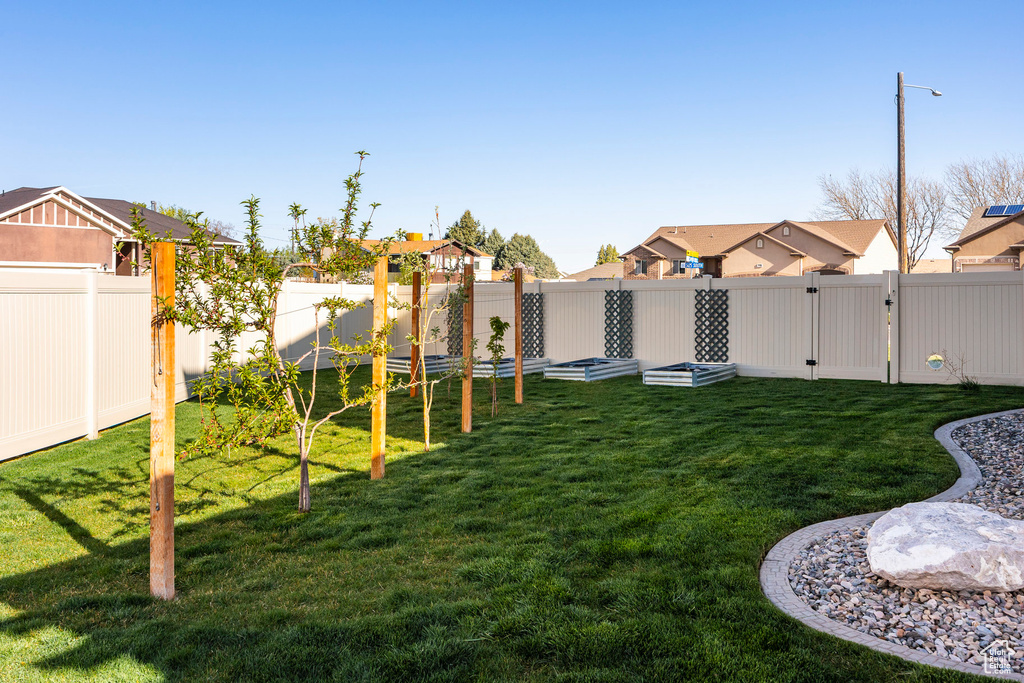 View of yard with a fenced backyard, a residential view, and a gate