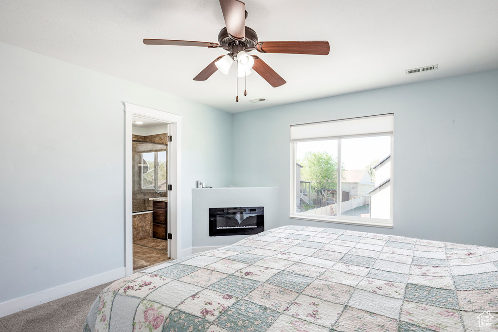 Unfurnished bedroom with a glass covered fireplace, baseboards, carpet, and visible vents