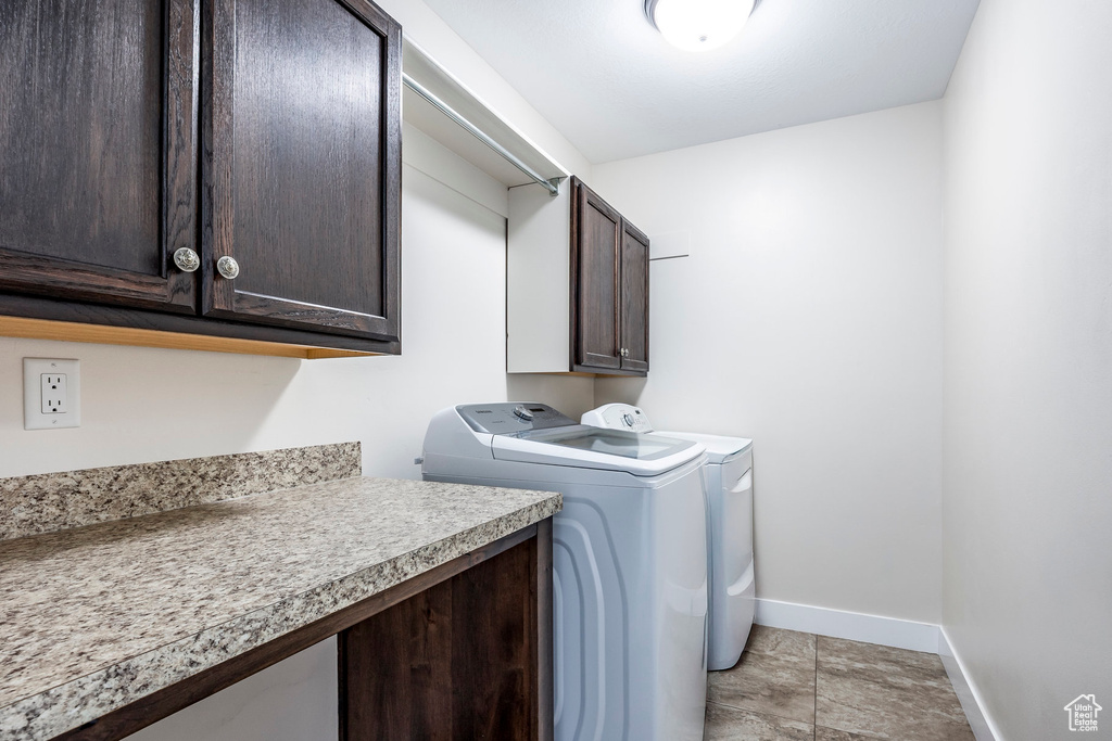 Laundry room featuring baseboards, washer and clothes dryer, and cabinet space