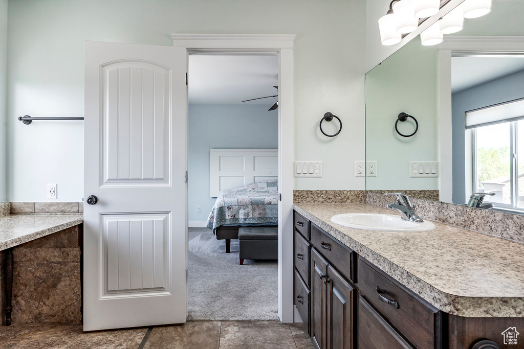 Bathroom featuring a ceiling fan, ensuite bathroom, and vanity