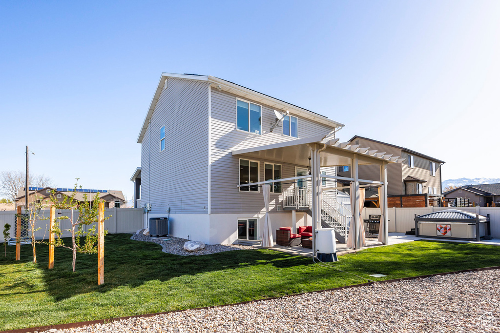 Back of property with a pergola, cooling unit, a patio, a fenced backyard, and stairway
