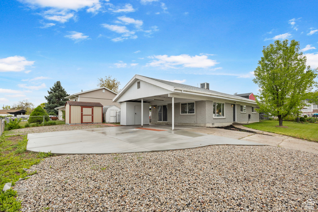 Single story home with a storage shed, an outbuilding, fence, a patio, and an attached carport