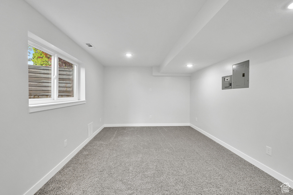 Basement with carpet flooring, recessed lighting, baseboards, and electric panel