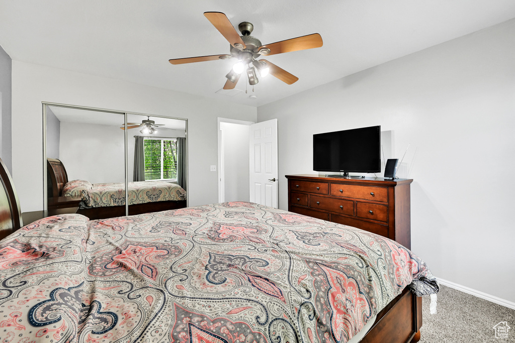 Bedroom with carpet flooring, a ceiling fan, baseboards, and a closet