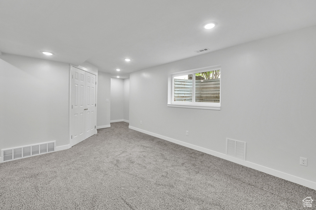 Basement with carpet floors, baseboards, and visible vents