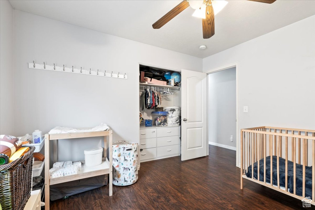 Bedroom featuring a ceiling fan, baseboards, wood finished floors, and a closet