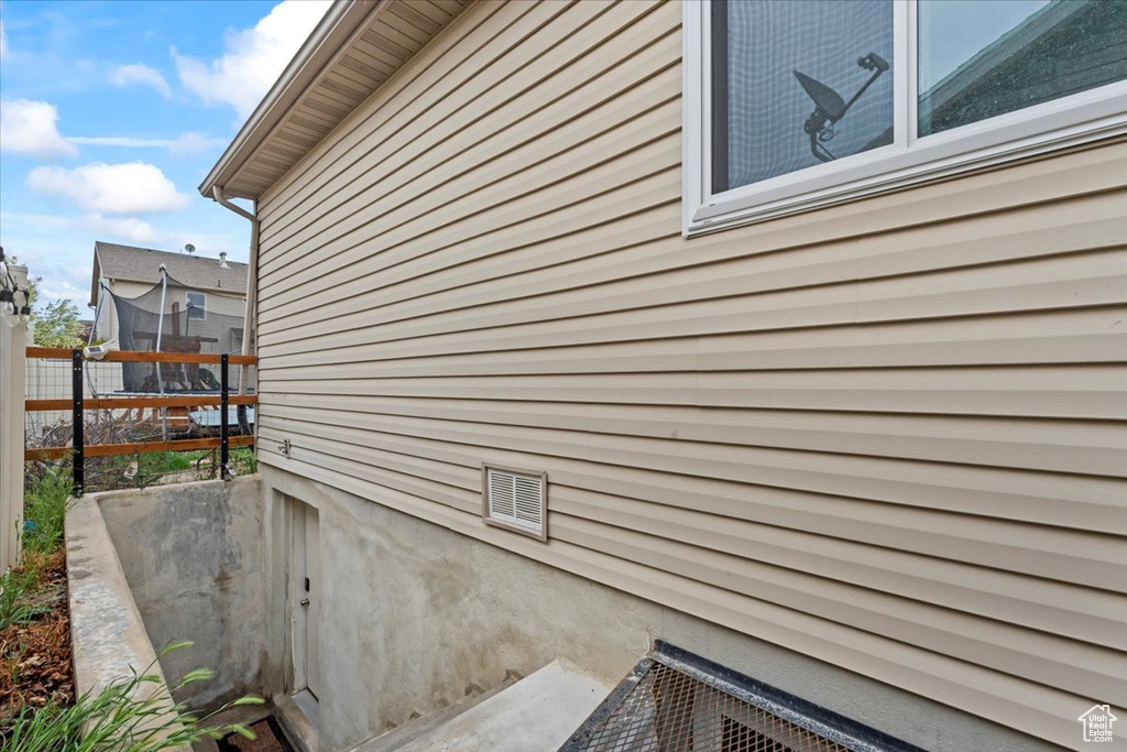 View of side of property featuring fence and a trampoline