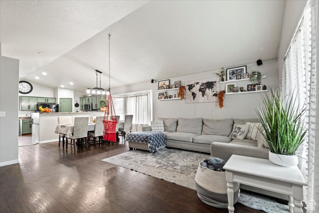 Living area with recessed lighting, baseboards, vaulted ceiling, and dark wood-style floors