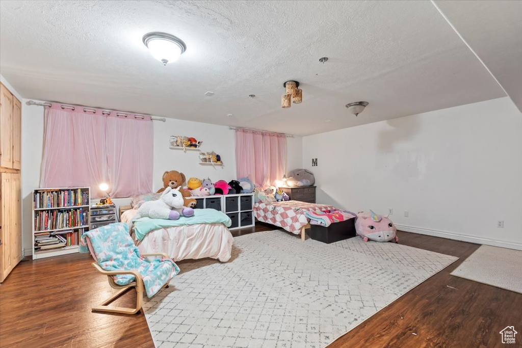Bedroom with a textured ceiling and wood finished floors