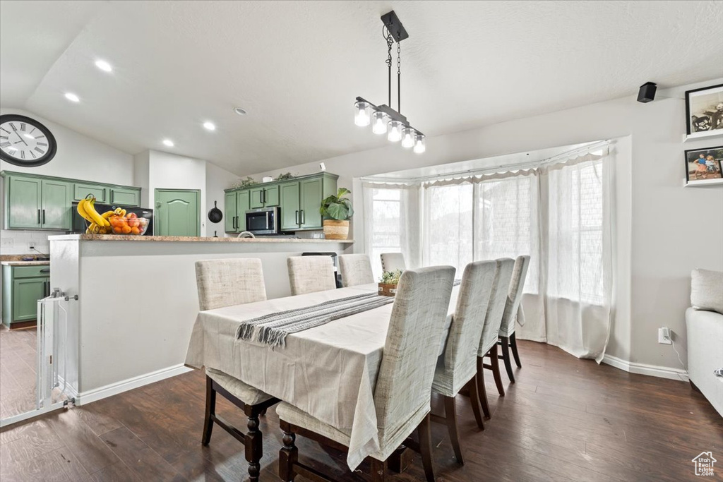Dining space with baseboards, dark wood-type flooring, recessed lighting, and lofted ceiling