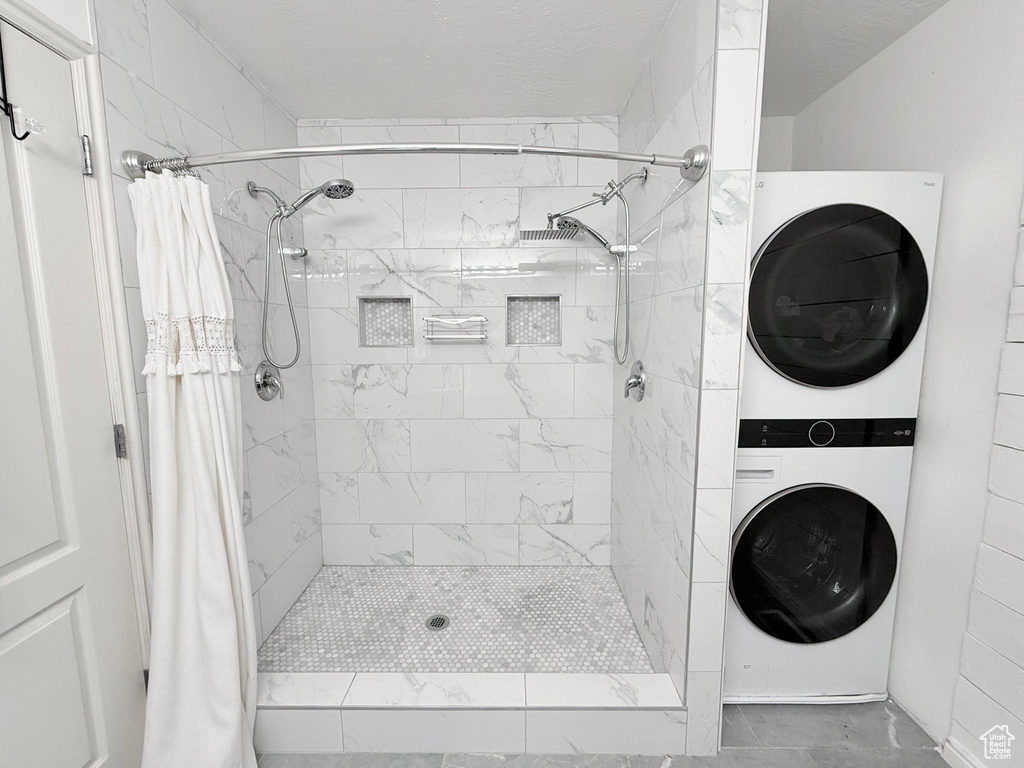 Bathroom with stacked washing machine and dryer and a shower stall