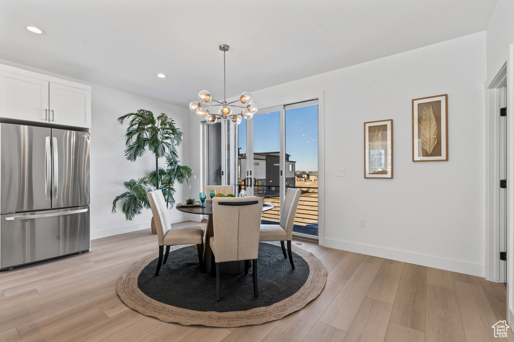 Dining space with light wood-type flooring, recessed lighting, baseboards, and a notable chandelier