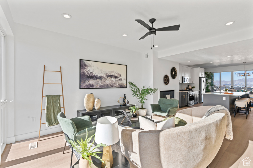Living area with recessed lighting, ceiling fan, visible vents, and light wood-style flooring
