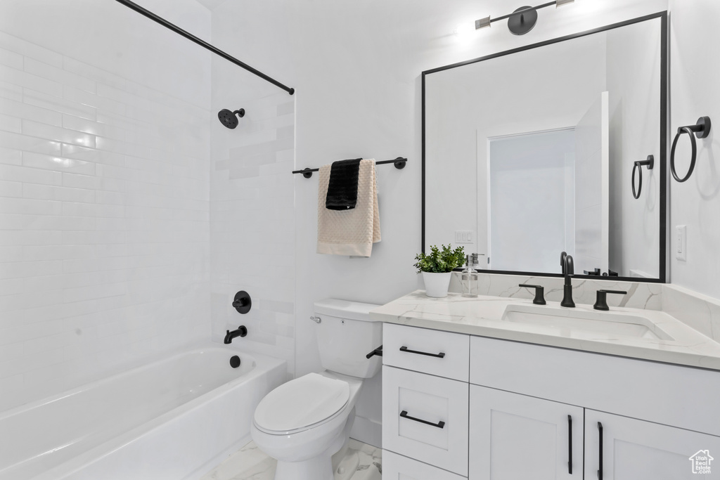 Full bath featuring vanity, marble finish floor, bathing tub / shower combination, and toilet
