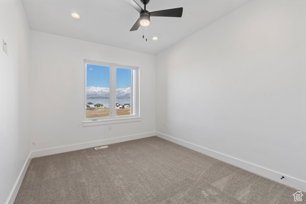 Spare room featuring a ceiling fan, visible vents, baseboards, carpet flooring, and recessed lighting