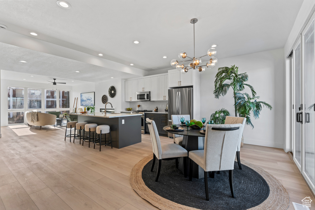 Dining area featuring recessed lighting, light wood finished floors, and ceiling fan with notable chandelier