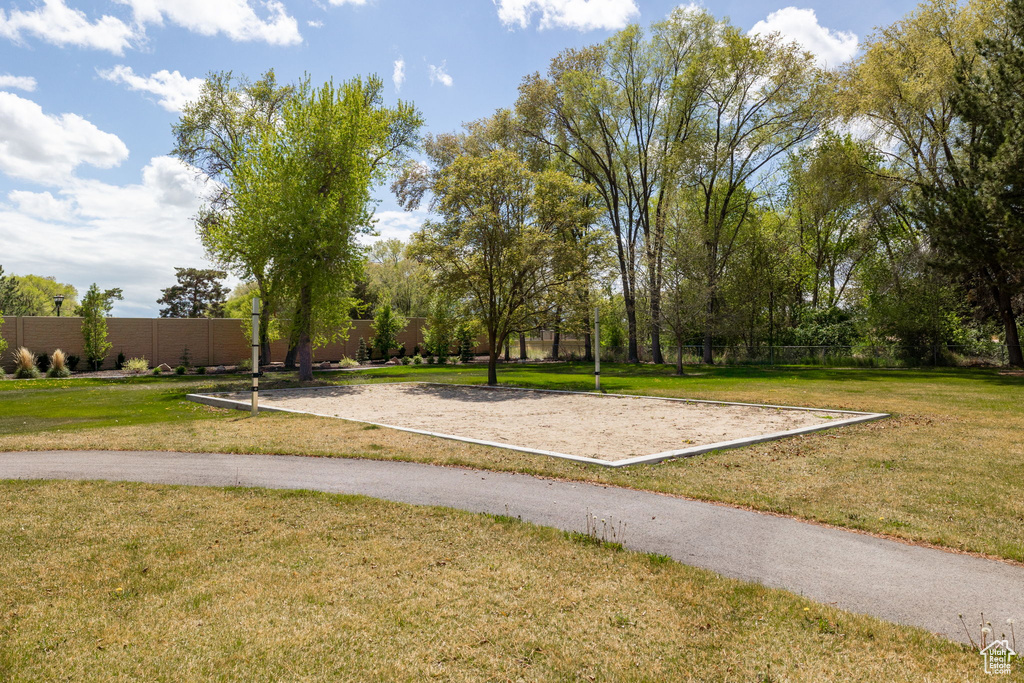 View of community with a yard, fence, and volleyball court