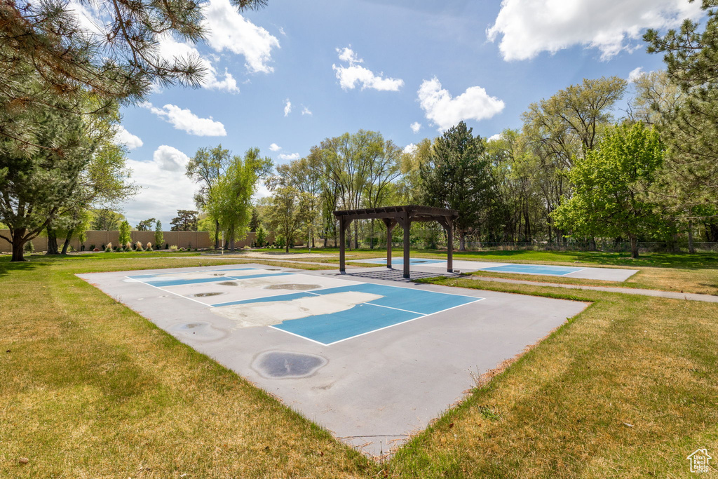 View of basketball court with a lawn, a pergola, fence, and community basketball court