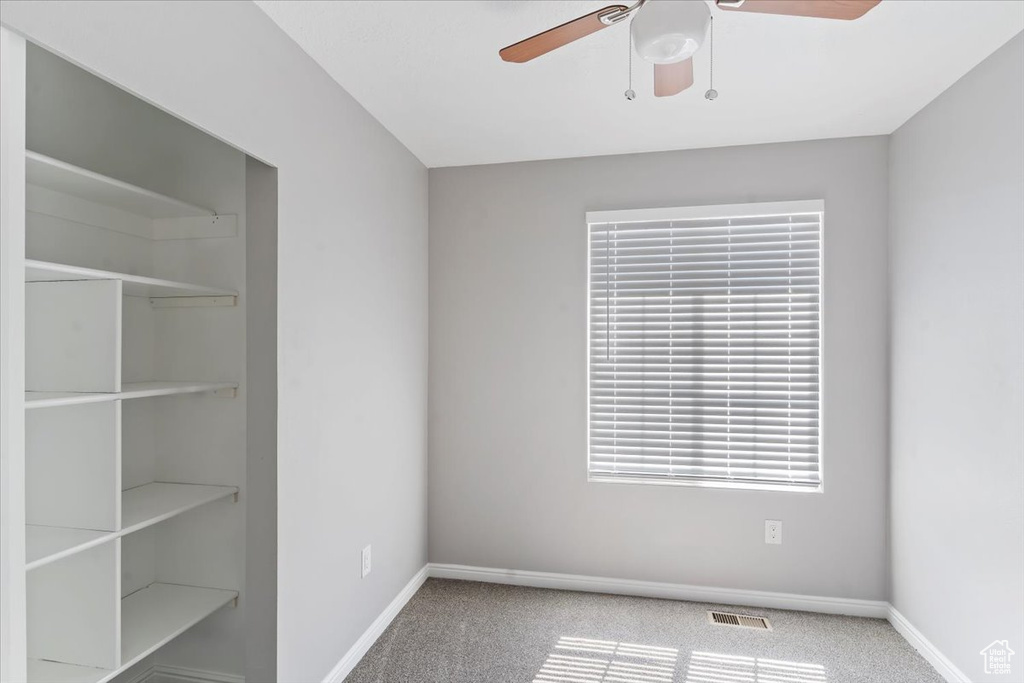 Unfurnished bedroom featuring carpet flooring, baseboards, a ceiling fan, and a closet