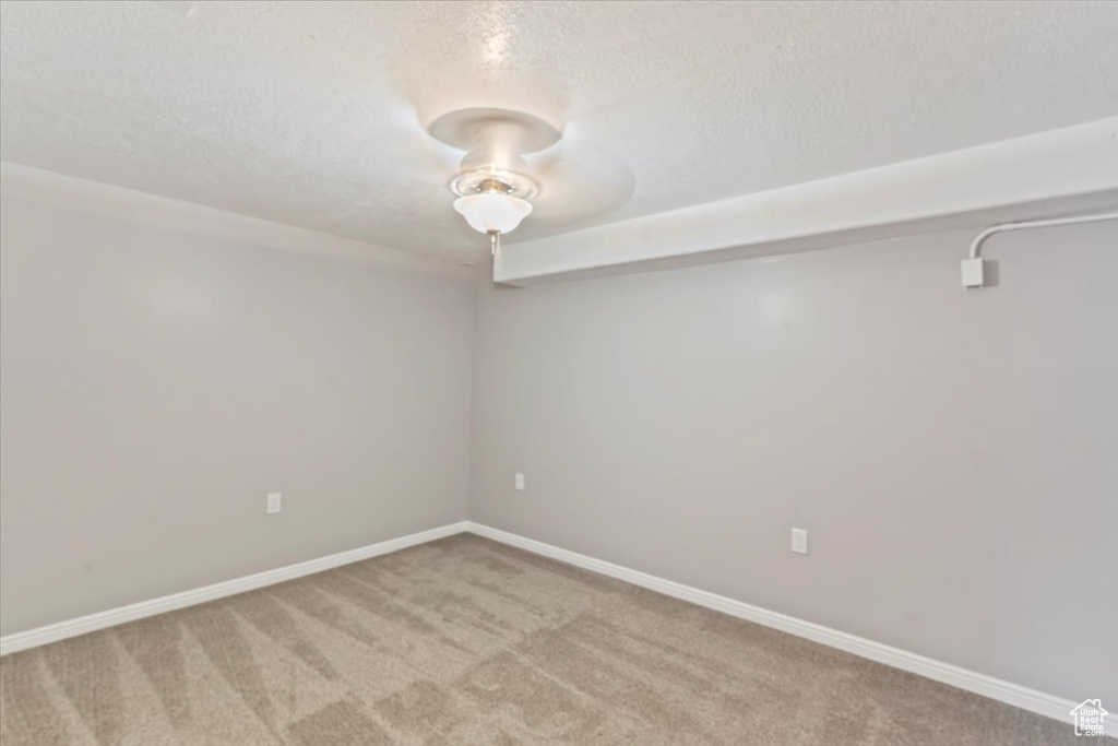 Spare room featuring carpet, a textured ceiling, and baseboards