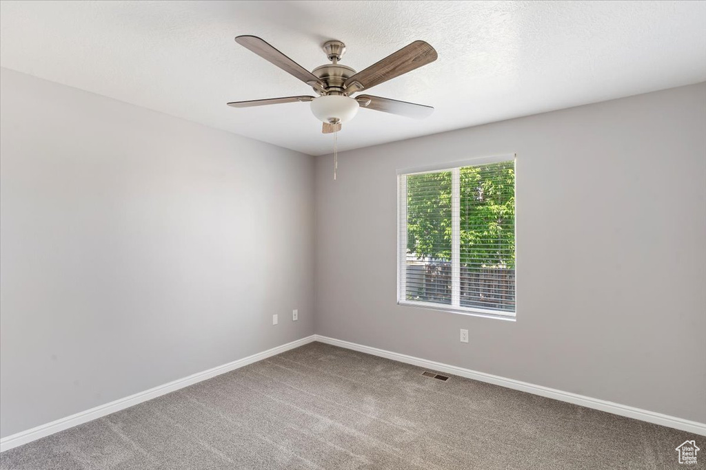 Empty room with carpet floors, baseboards, and ceiling fan