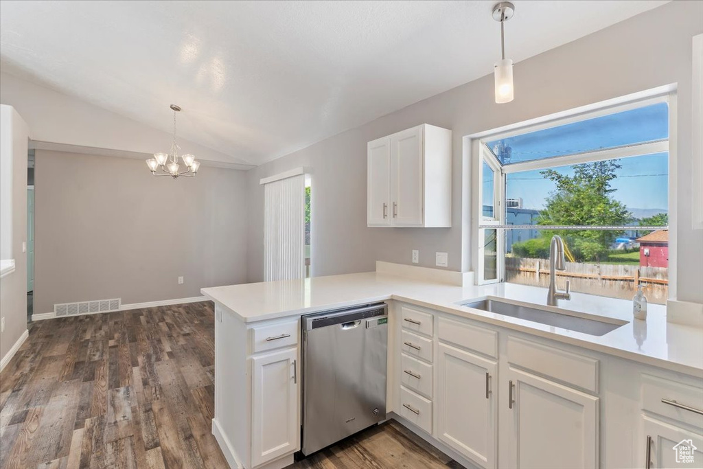 Kitchen with stainless steel dishwasher, a sink, a chandelier, white cabinets, and light countertops