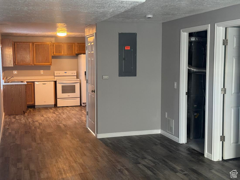Kitchen featuring a textured ceiling, dark wood-style flooring, electric panel, and white appliances