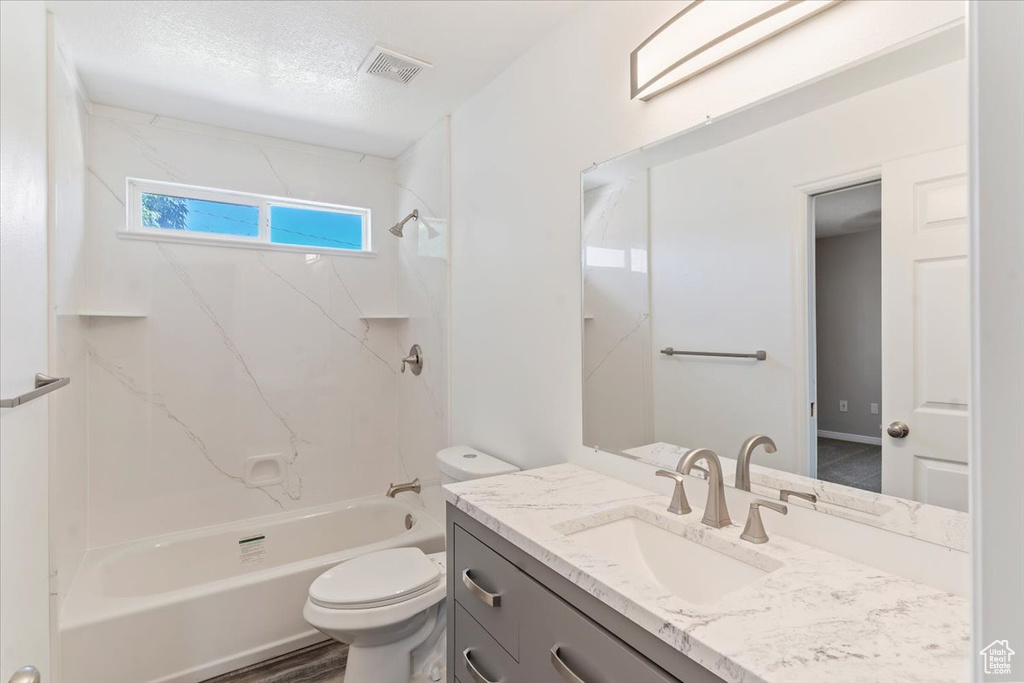 Full bathroom with toilet, vanity, and shower / washtub combination