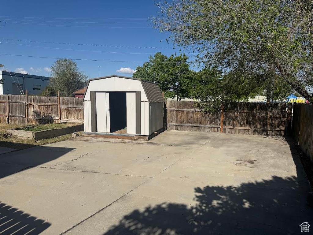 View of shed with a fenced backyard and a garden