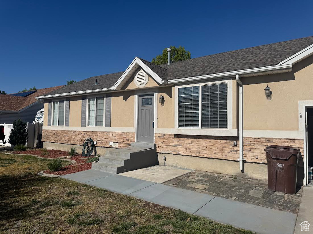 Ranch-style home with stone siding and stucco siding