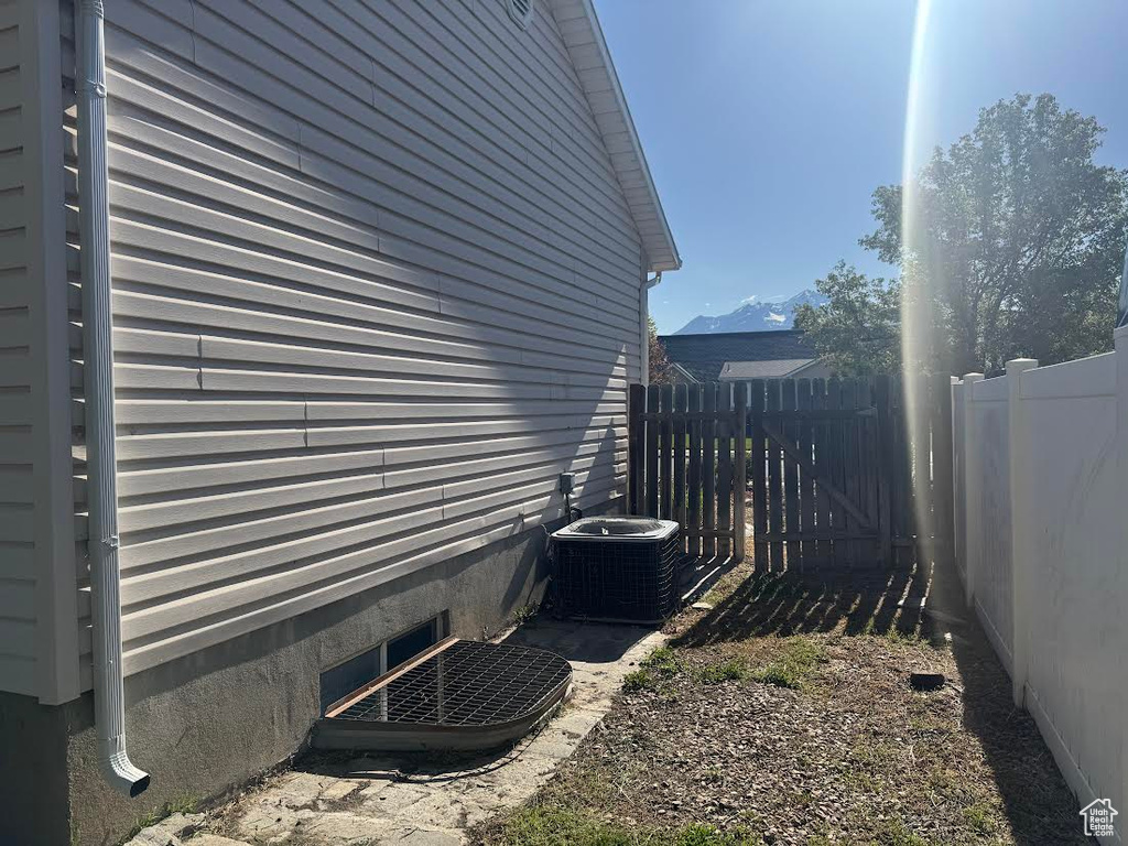 View of side of property featuring central AC and fence