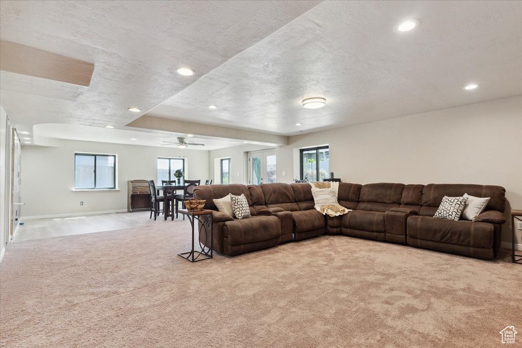Living room with recessed lighting, ceiling fan, light colored carpet, and a textured ceiling