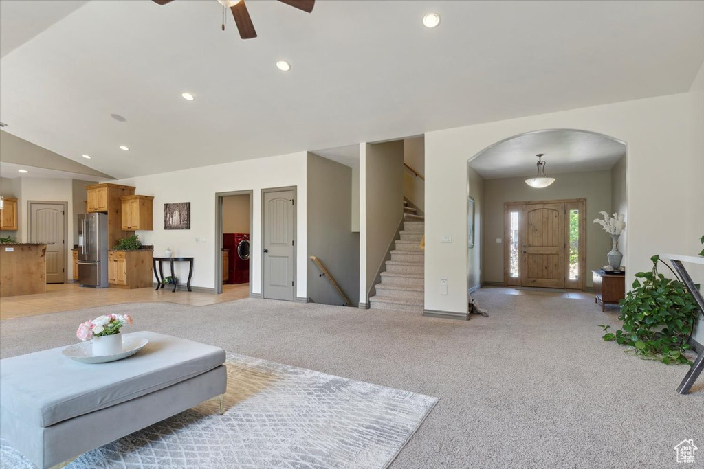 Living room with stairs, ceiling fan, light colored carpet, recessed lighting, and arched walkways