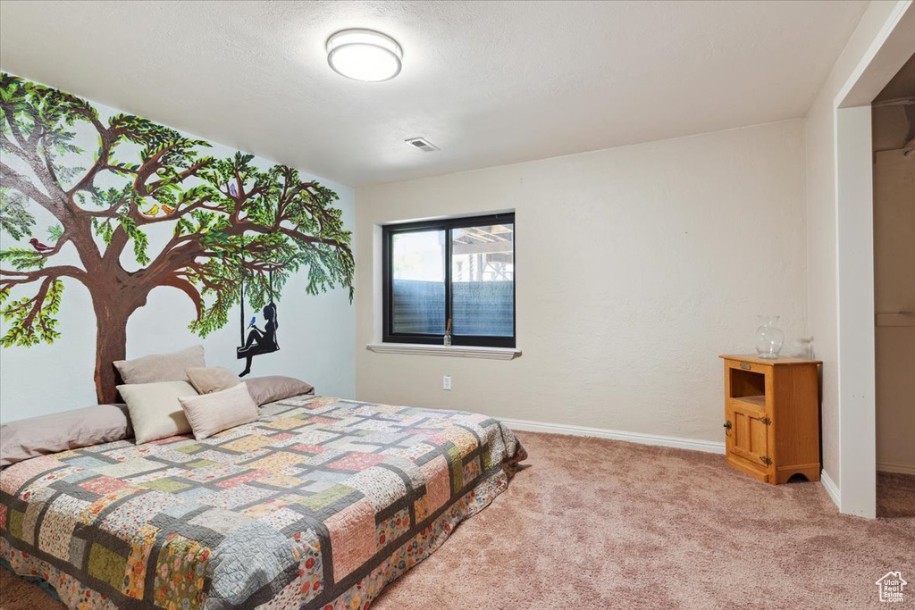Carpeted bedroom with baseboards and visible vents