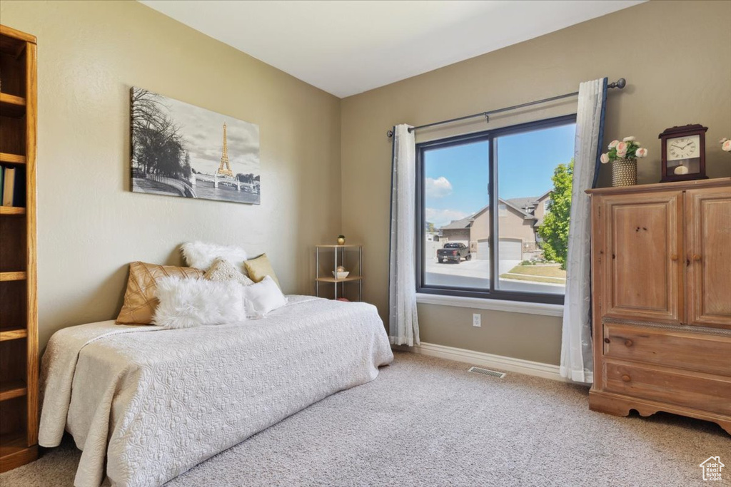 Carpeted bedroom with baseboards and visible vents