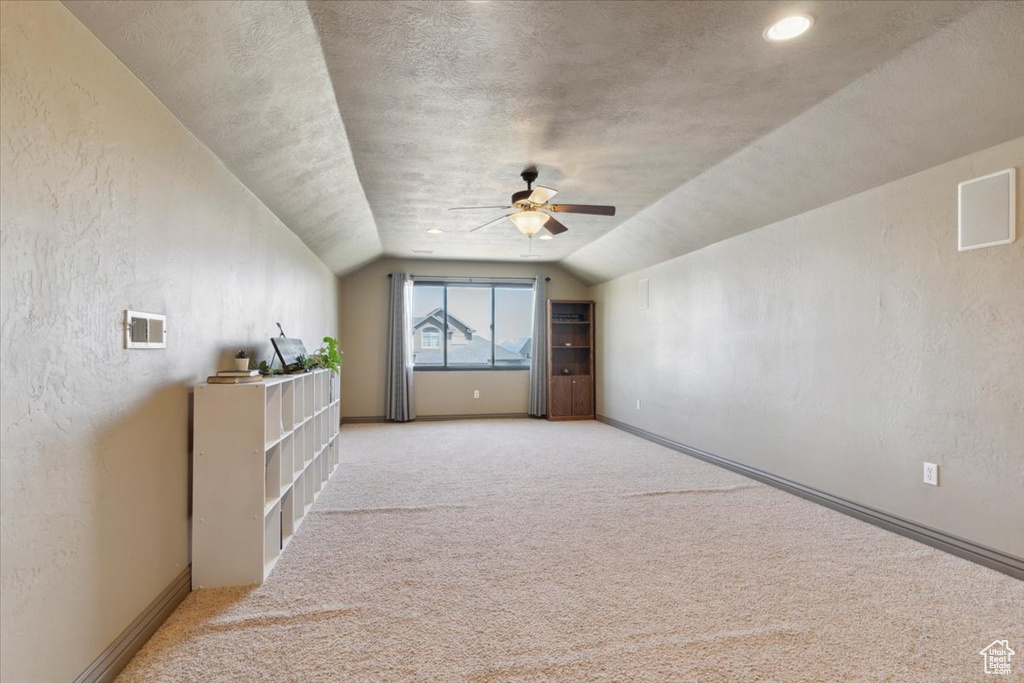 Bonus room with a ceiling fan, light colored carpet, visible vents, and lofted ceiling