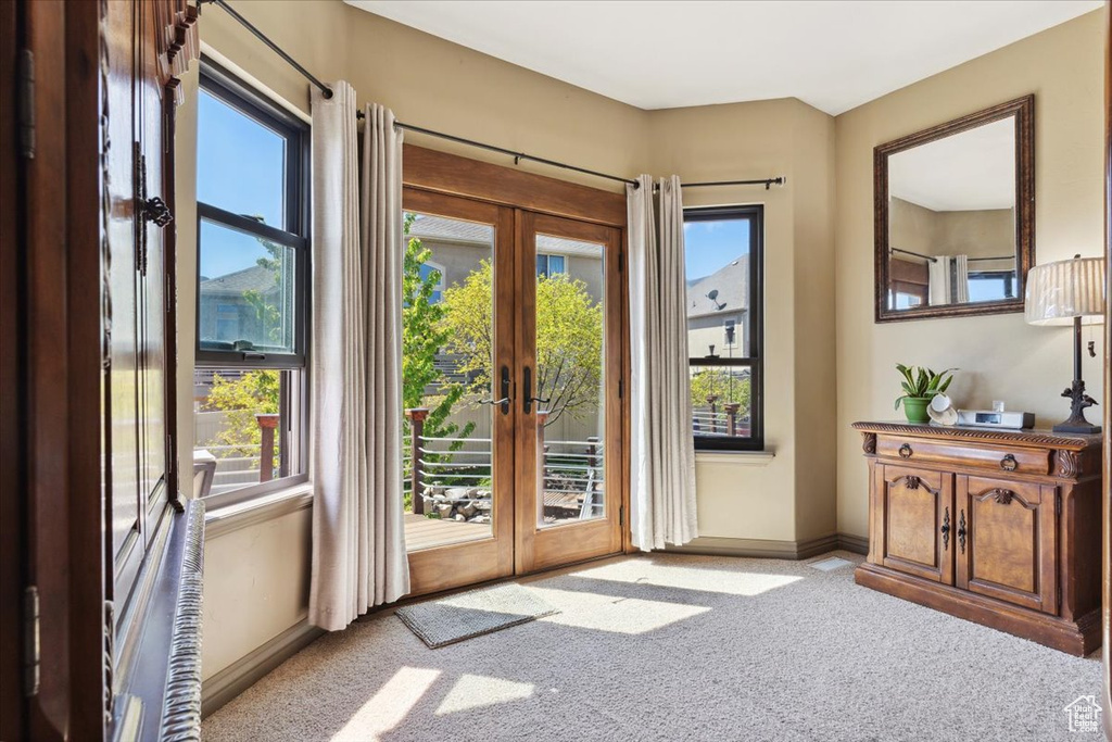 Entryway featuring carpet flooring, baseboards, and french doors