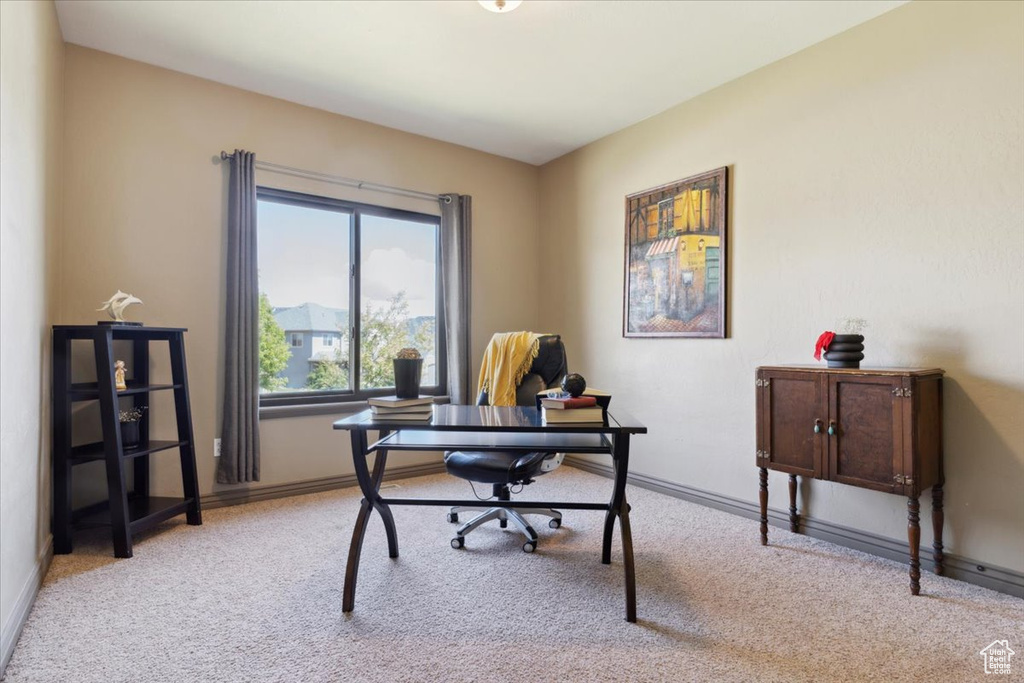 Home office with baseboards and light carpet
