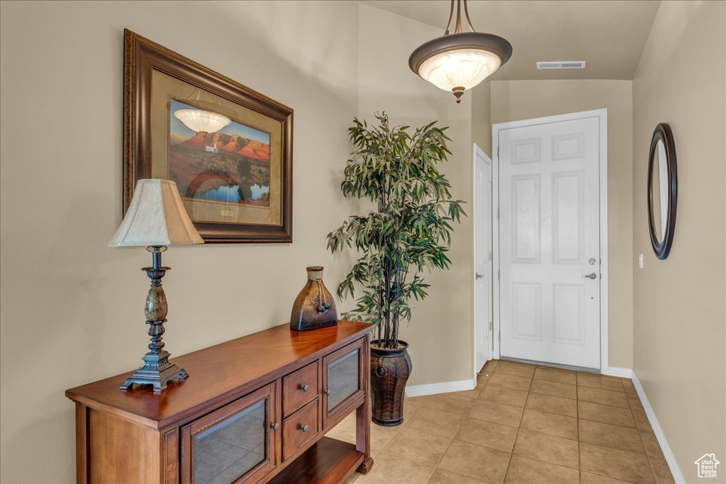 Entrance foyer with baseboards, light tile patterned floors, and visible vents