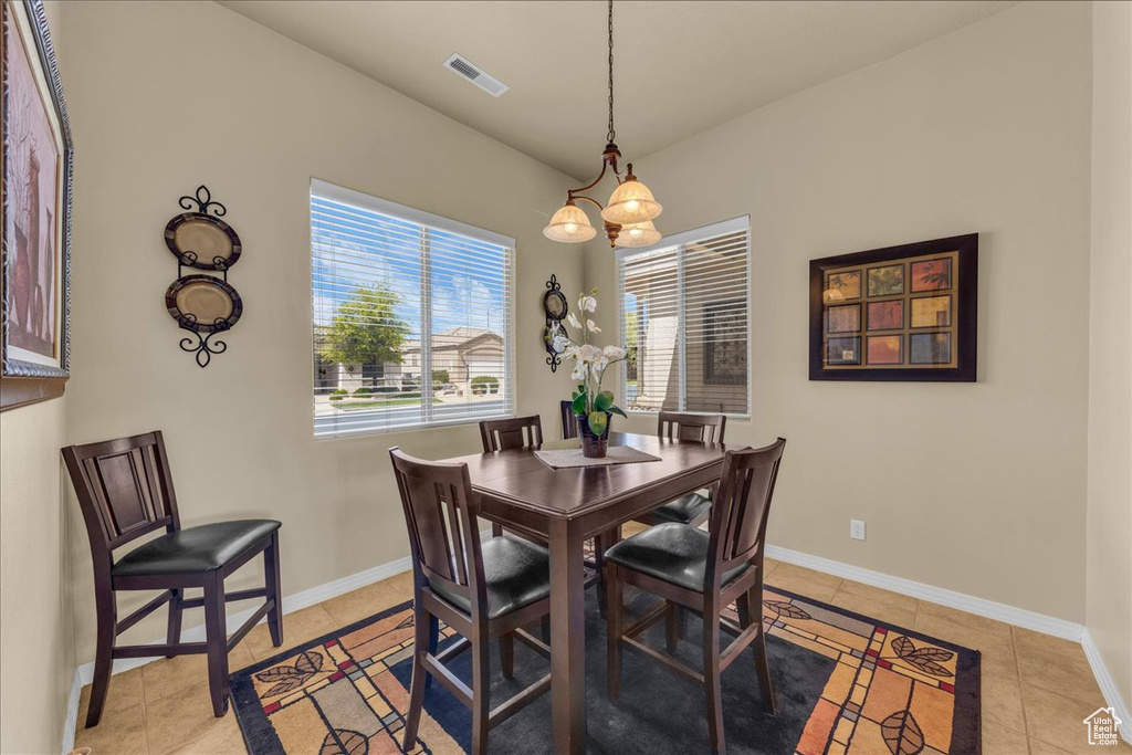 Dining area featuring light tile patterned floors, baseboards, and visible vents