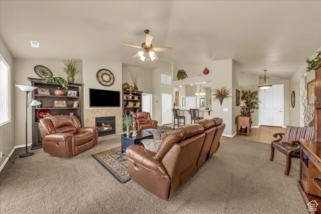 Carpeted living room featuring a ceiling fan, baseboards, visible vents, and a tile fireplace