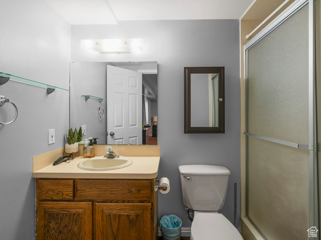Full bathroom featuring an enclosed shower, vanity, and toilet