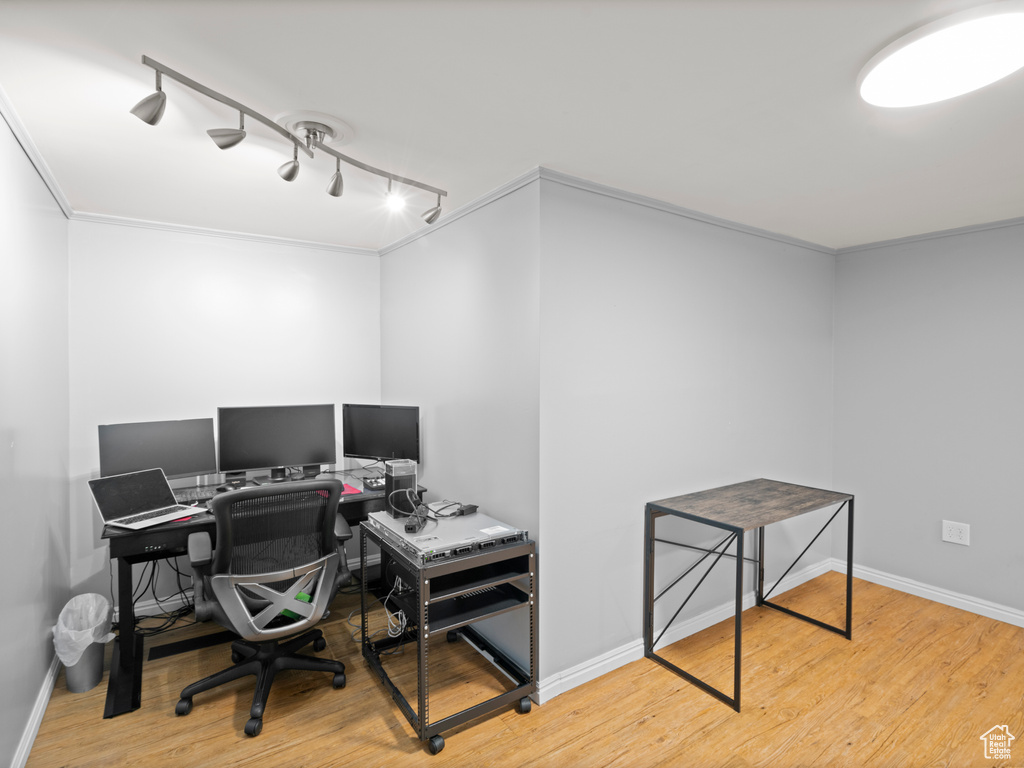 Office featuring baseboards, rail lighting, crown molding, and wood finished floors