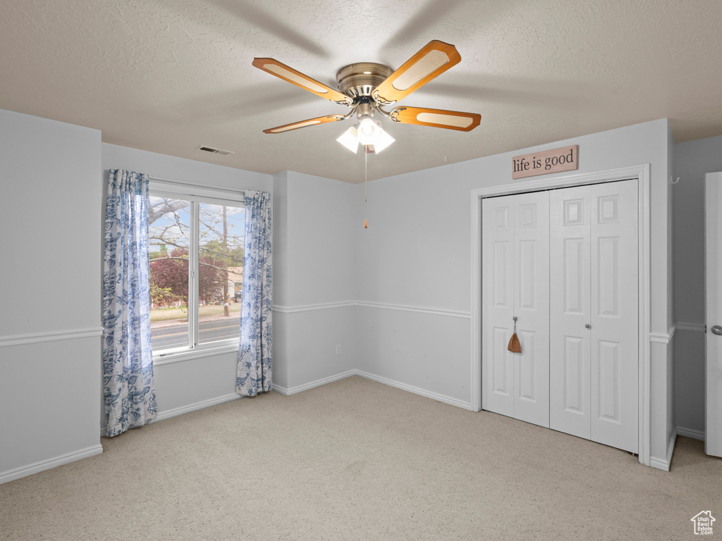 Unfurnished bedroom with visible vents, a textured ceiling, carpet, and baseboards