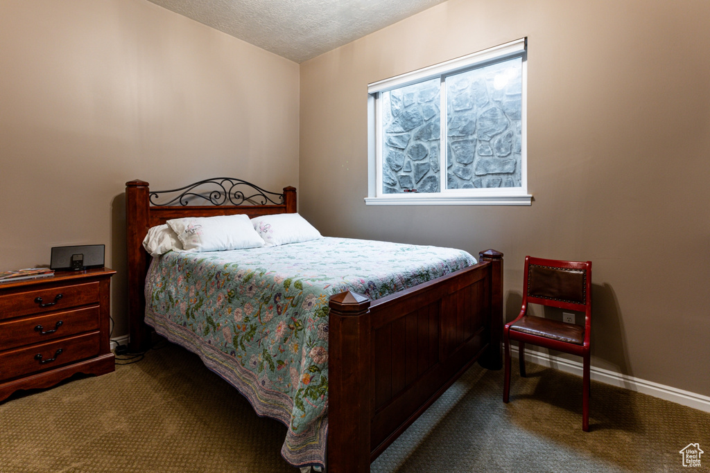 Carpeted bedroom with baseboards and a textured ceiling
