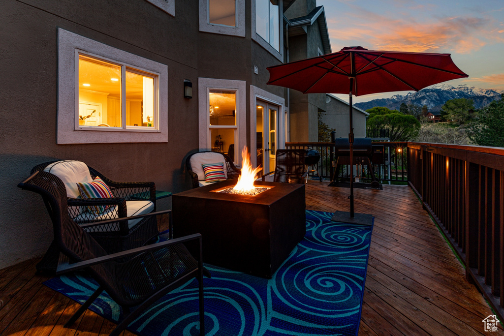 Deck featuring a mountain view and an outdoor living space with a fire pit