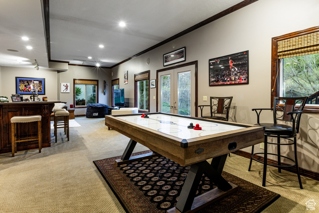 Recreation room featuring recessed lighting, light colored carpet, ornamental molding, and a dry bar