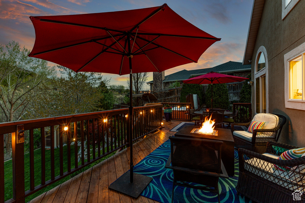 Deck at dusk with an outdoor living space with a fire pit