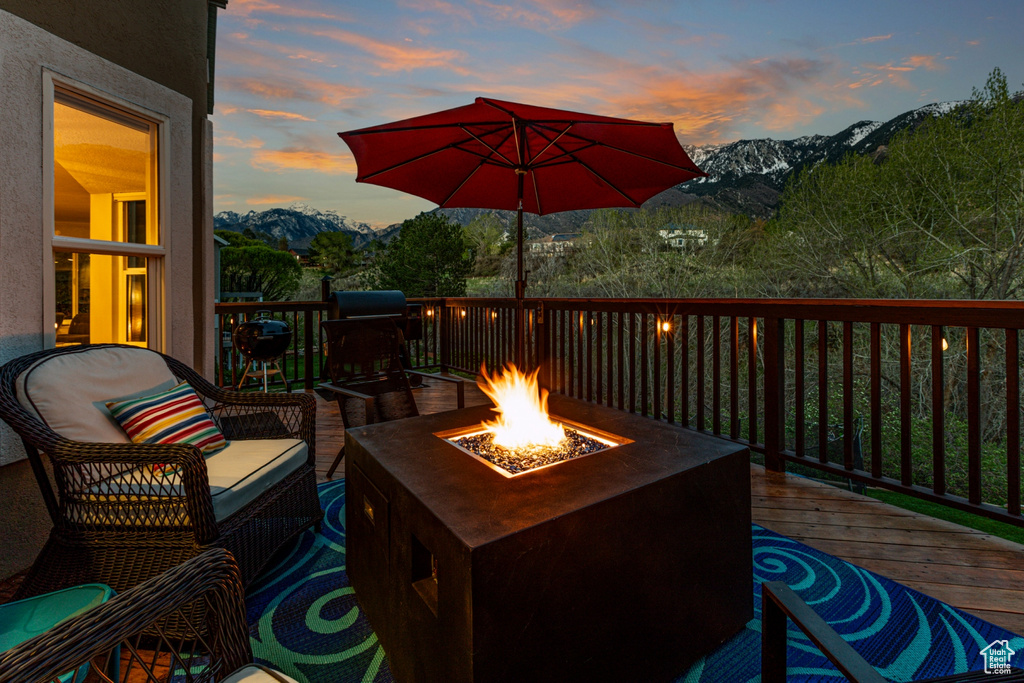 Wooden deck with a fire pit and a mountain view