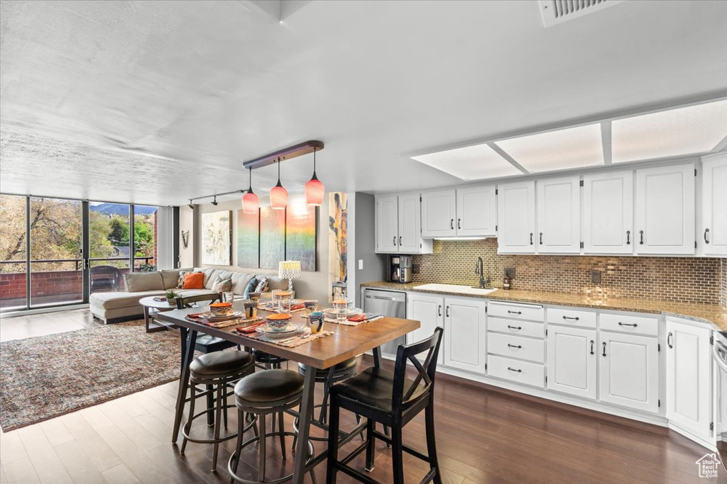 Kitchen featuring open floor plan, dark wood-style floors, a sink, and tasteful backsplash